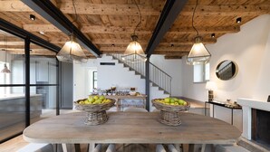 A dining area with a wooden table, wicker baskets of fruit, and modern pendant lighting. - Villa Mojana, Limonta, Bellagio | The D’Angelo Family Collection (Oliveto Lario)