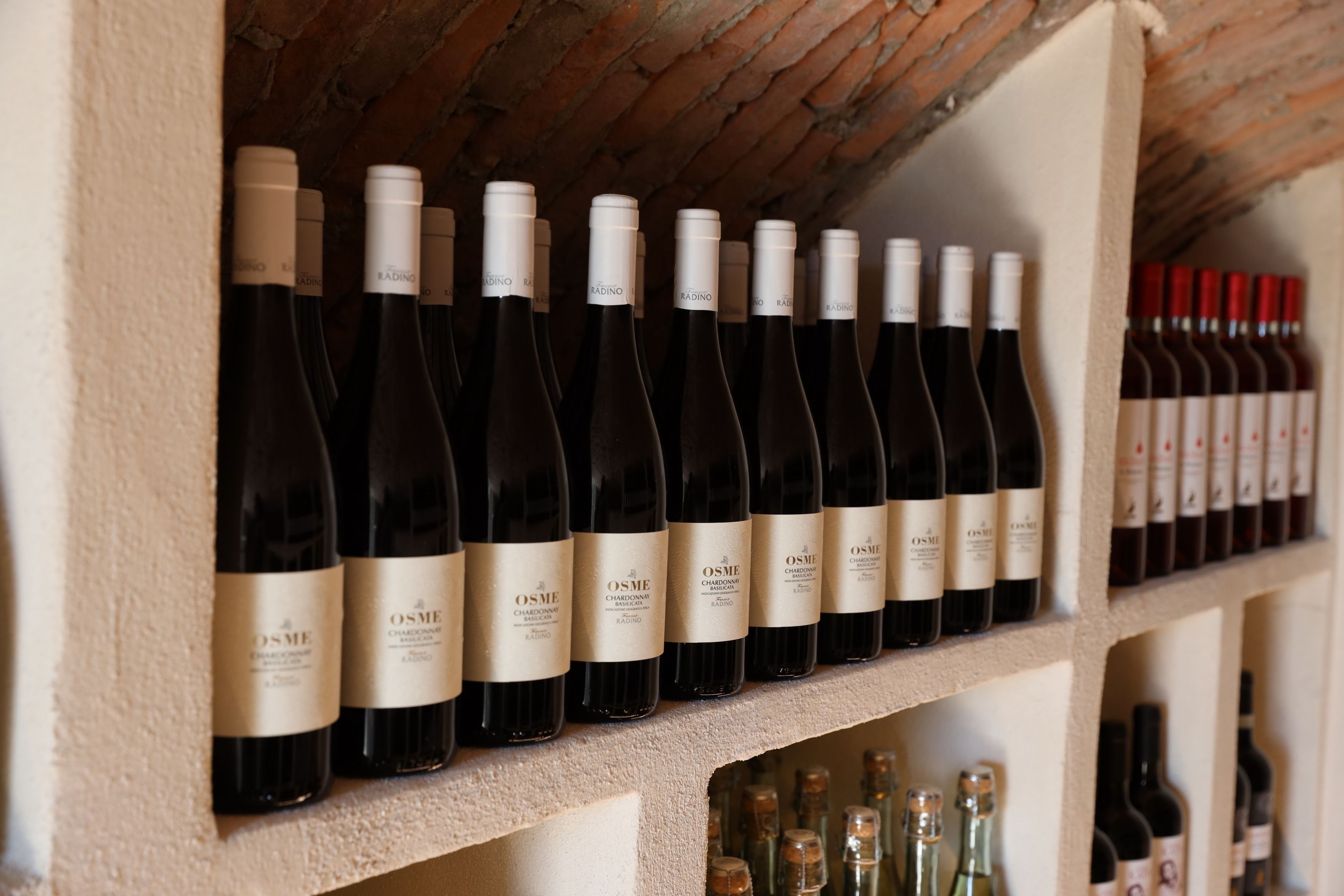A wine rack with multiple bottles of Osme Chardonnay.