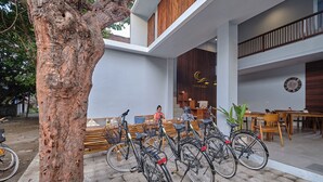 A modern building with a wooden facade, a reception area, and bicycles parked outside. - Gili Kama Hotel & Villa (Gili Trawangan)