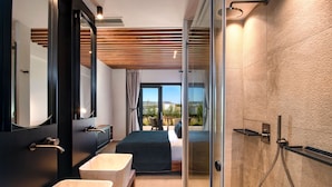 Un baño moderno con un espejo grande, dos lavamanos, una ducha y una cama con vistas.