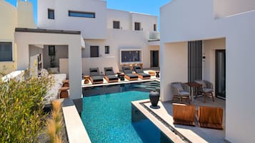 Una piscina cubierta, una piscina al aire libre, tumbonas