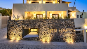 Un edificio moderno de dos pisos con fachada de piedra y ventanas iluminadas.