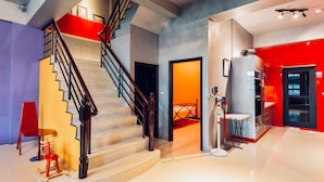 Un interior moderno con una escalera, un comedor y una cocina.