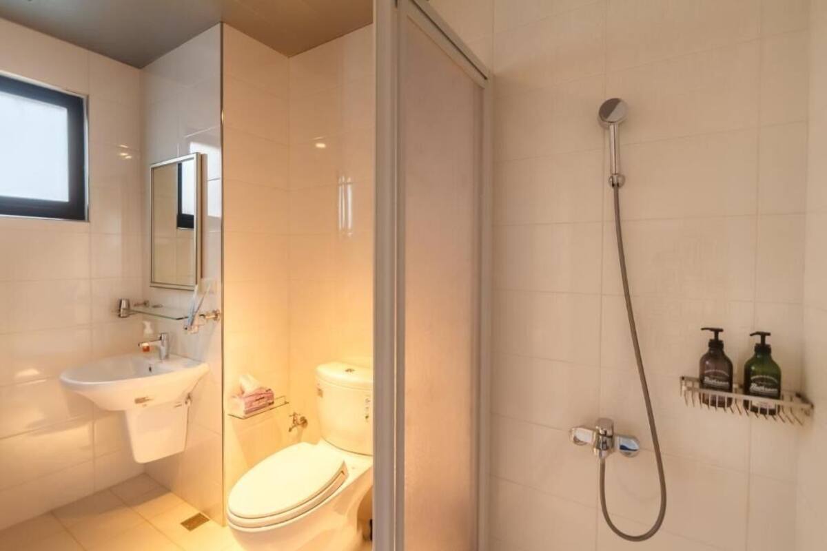 A modern bathroom with a glass-enclosed shower, a sink, and a toilet.