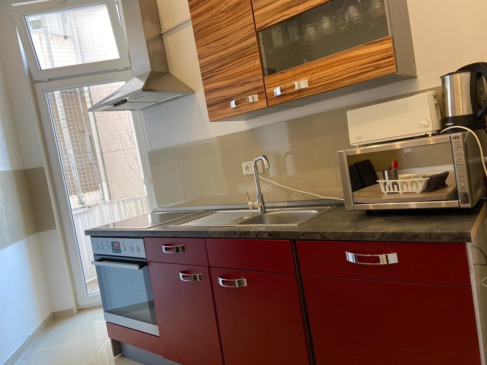 A modern kitchen with a built-in oven, a microwave, and a stainless steel sink.