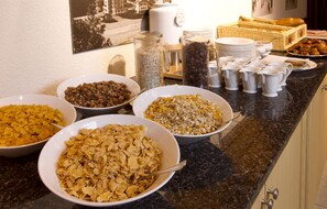A breakfast buffet with various cereals, coffee, and pastries. - Apartement Eigerpeak (Lauterbrunnen)