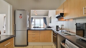 Una cucina moderna con elettrodomestici in acciaio inossidabile, mobili in legno e un'ampia finestra con tende.