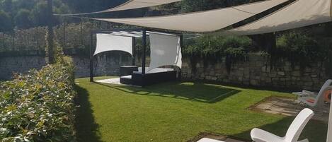 A patio area with a seating arrangement and a pergola providing shade.