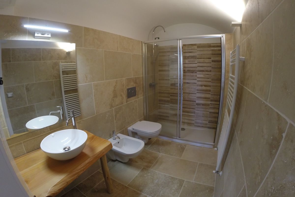 Een badkamer met een wastafel, toilet, douchecabine en bidet.