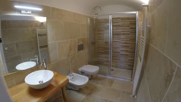 Ein Badezimmer mit Waschbecken, Bidet, Toilette und Duschkabine.