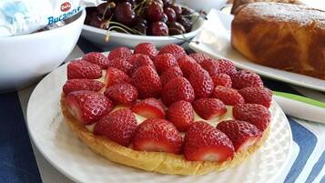 Une assiette de fraises disposées sur une pâtisserie.