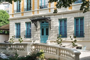 A classical building with a central entrance, a covered walkway, and a decorative balustrade. - Villa 216 (Lyon)