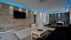 Apartamento de lujo, 3 habitaciones | Zona de estar | Una televisión de pantalla plana