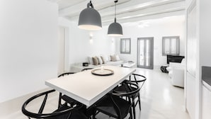 Une cuisine moderne dotée d’un îlot central, de chaises noires et de luminaires suspendus.