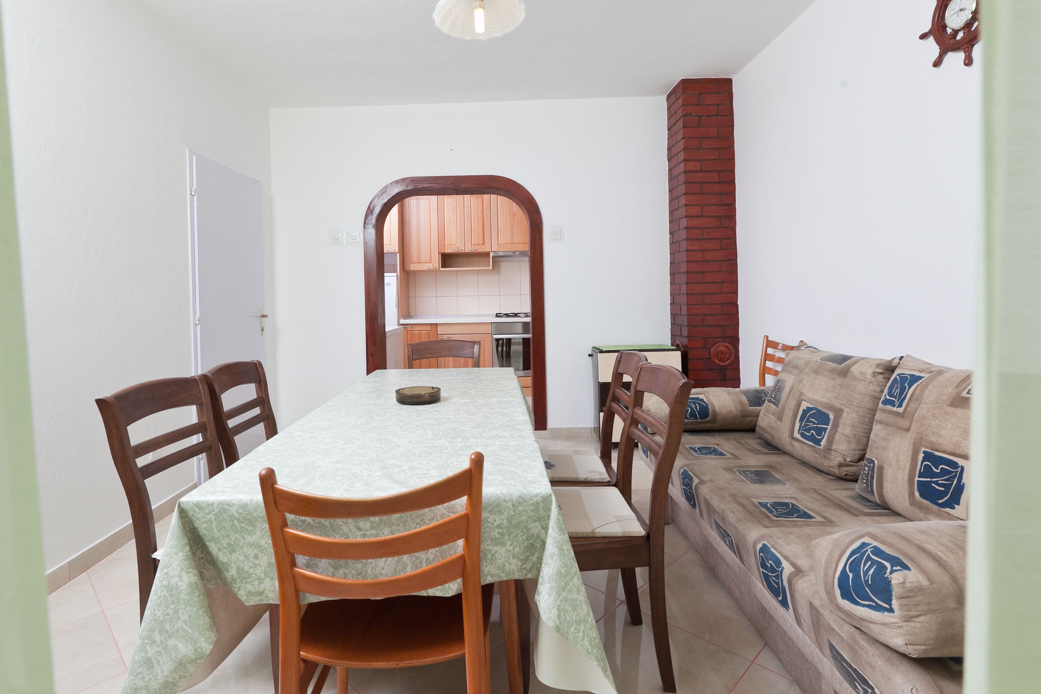 A dining area with a table, chairs, and a sofa.