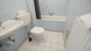 Un baño con inodoro, lavamanos y bañera.