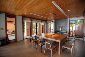 A spacious dining area with a large wooden table, multiple chairs, and a modern ceiling design. - 4BR Residence Pool Villa Ocean View - Sri panwa (G11) (Phuket)