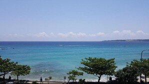 A coastal view with clear skies, calm sea, and a promenade lined with trees. - Hearty Homestay (Hengchun)