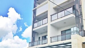 Un immeuble à plusieurs étages doté d’une entrée abritée et d’un balcon.