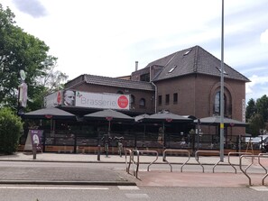 A restaurant named Brasserie with outdoor seating and a Duvel-branded awning.