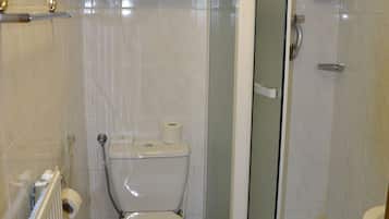 A bathroom with a toilet, a shower enclosure, and a radiator.