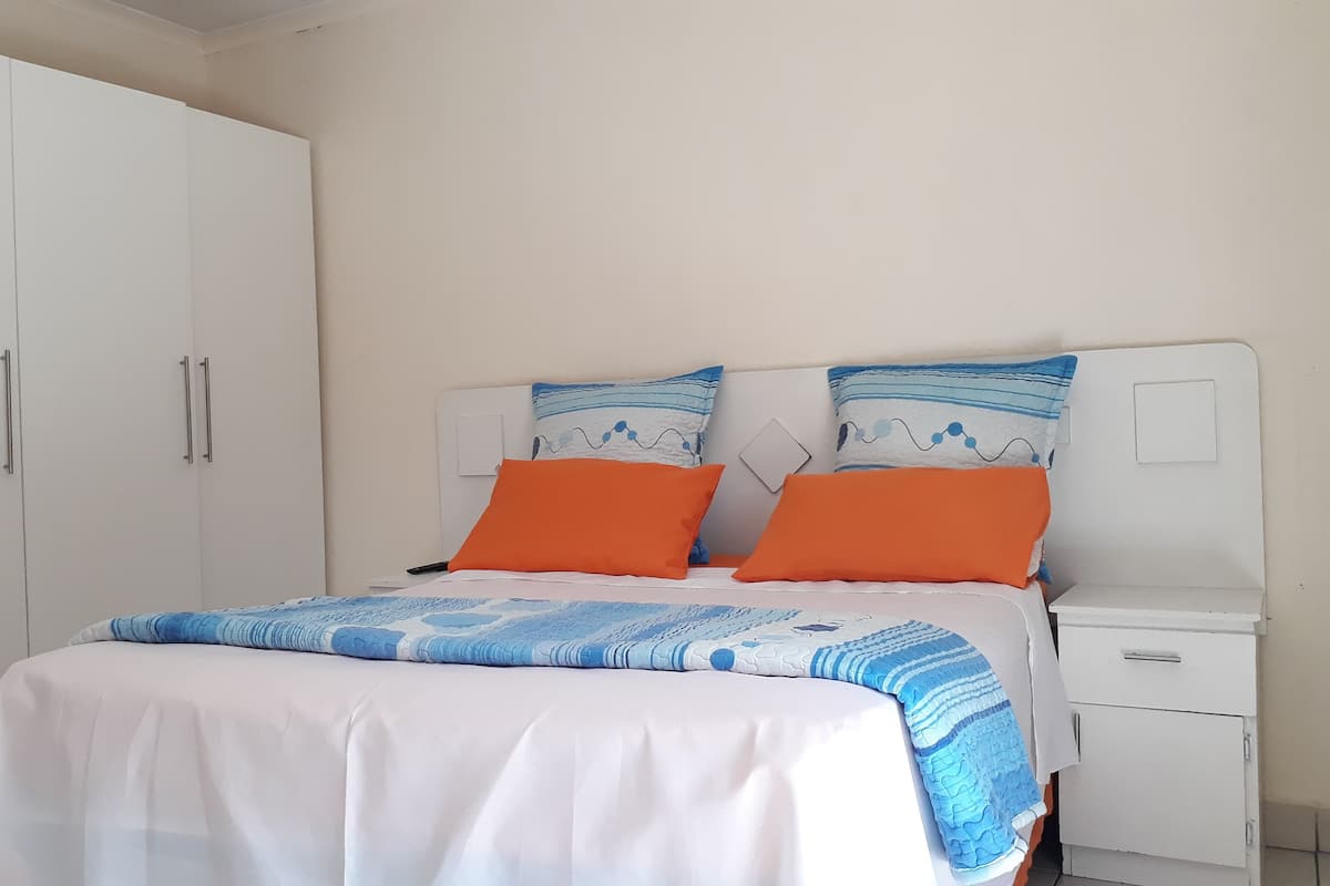 Habitación básica | Tabla de planchar con plancha y ropa de cama