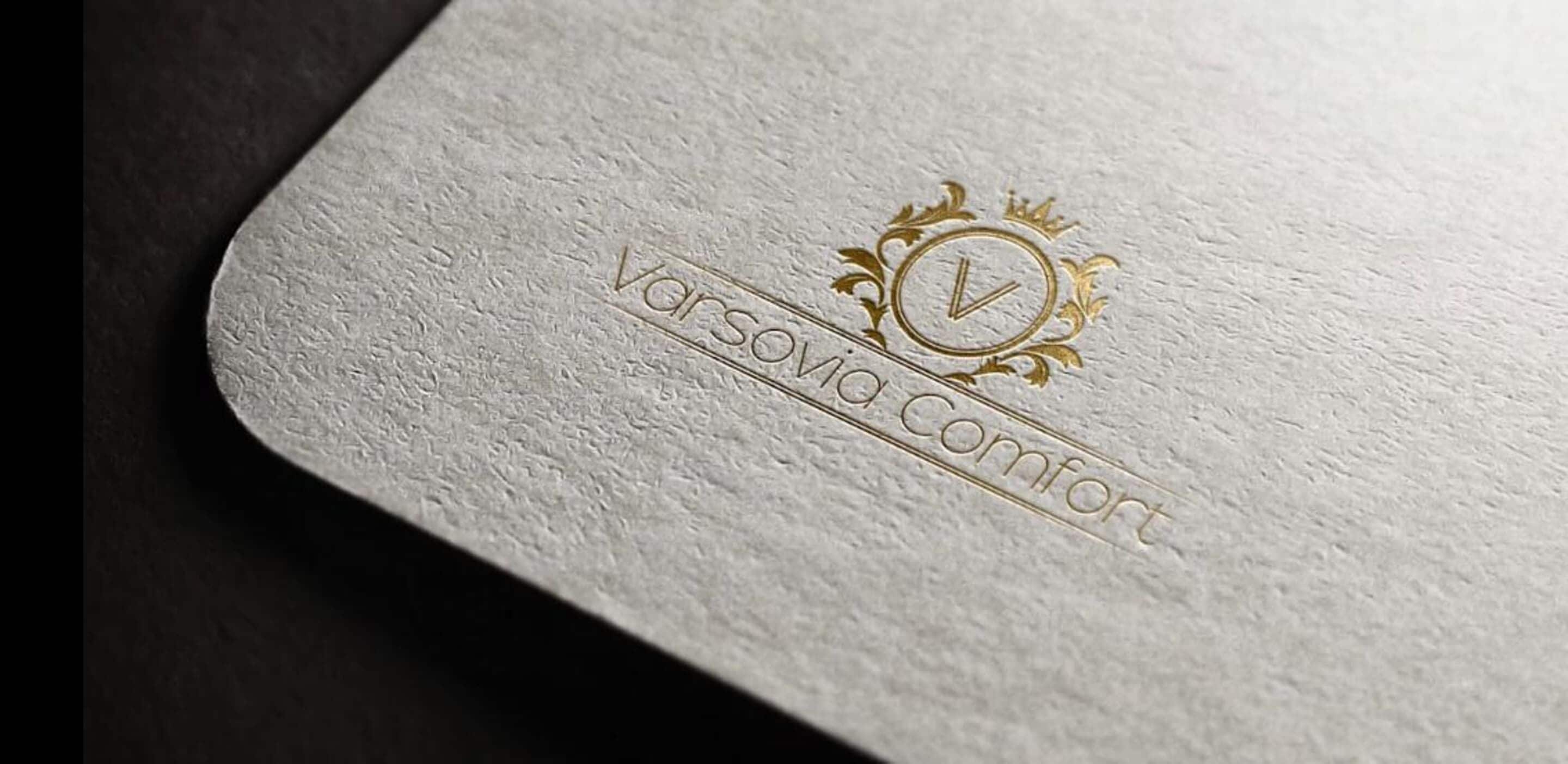 A textured surface with embossed text "Varsovia Comfort" and a decorative emblem.