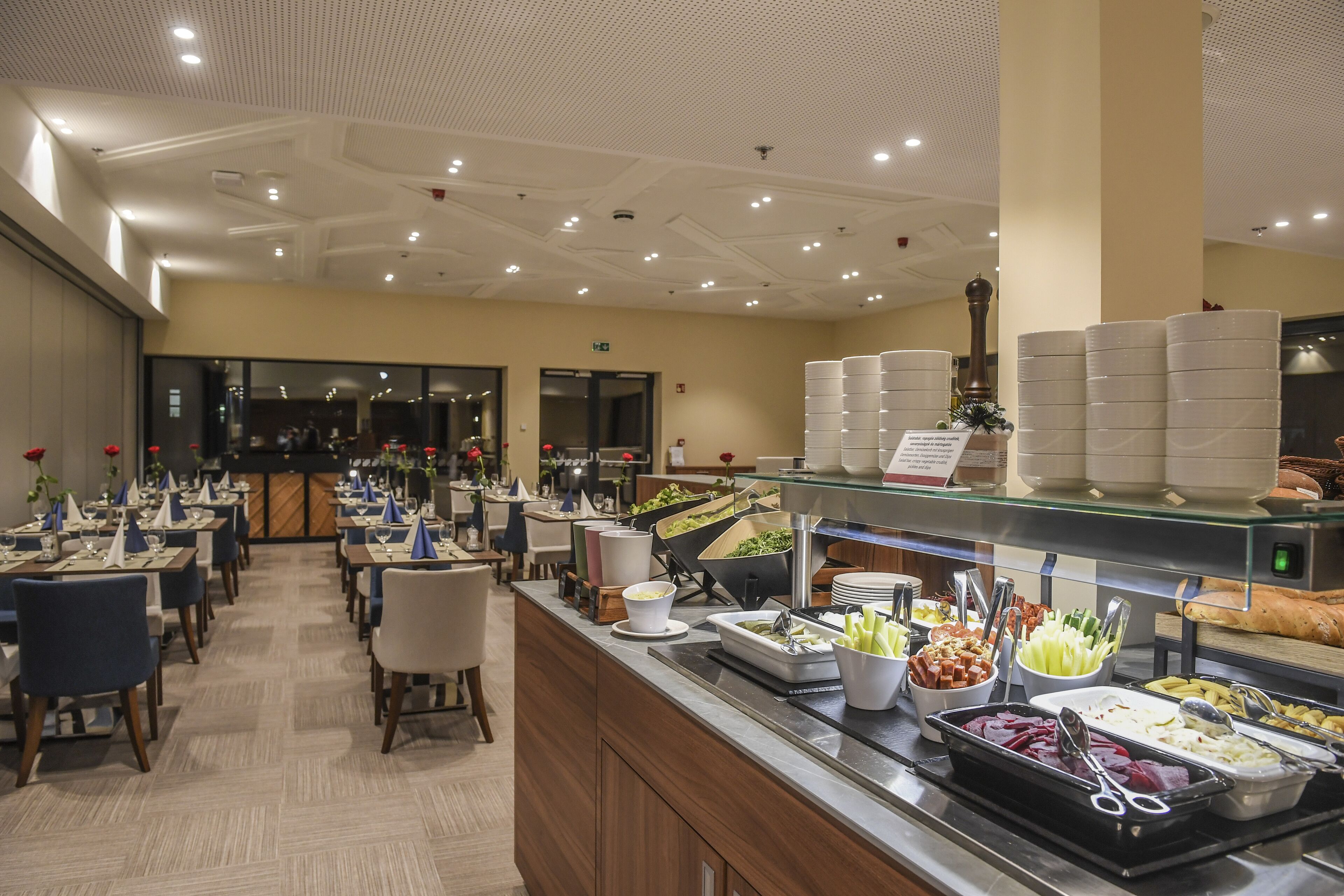 A buffet area with multiple serving stations, a variety of food options, and a seating area with tables and chairs.