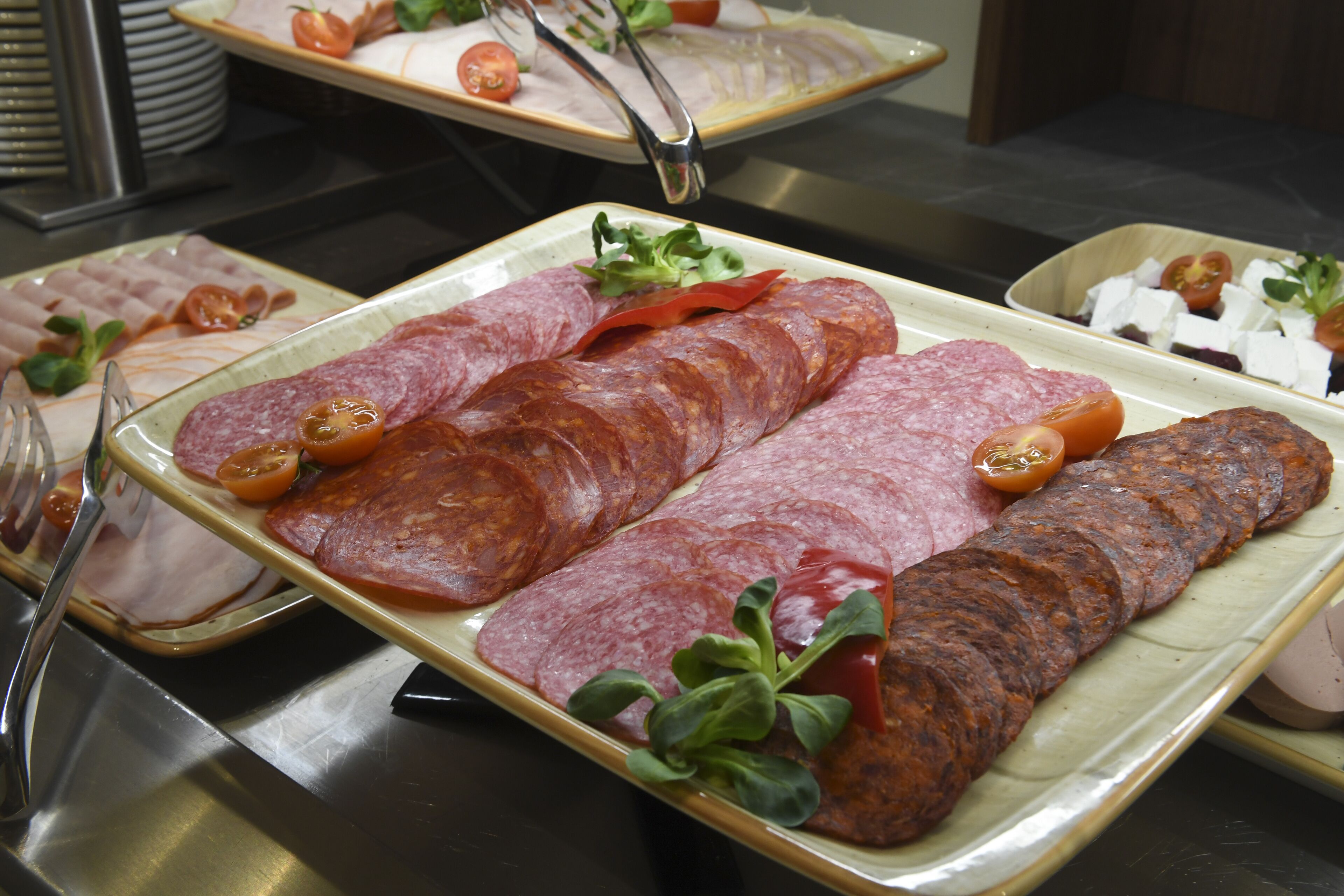 Een buffet met verschillende vleesschotels en garneringen.