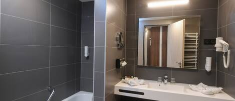 Un baño moderno con una bañera, un tocador con espejo y un perchero para toallas.