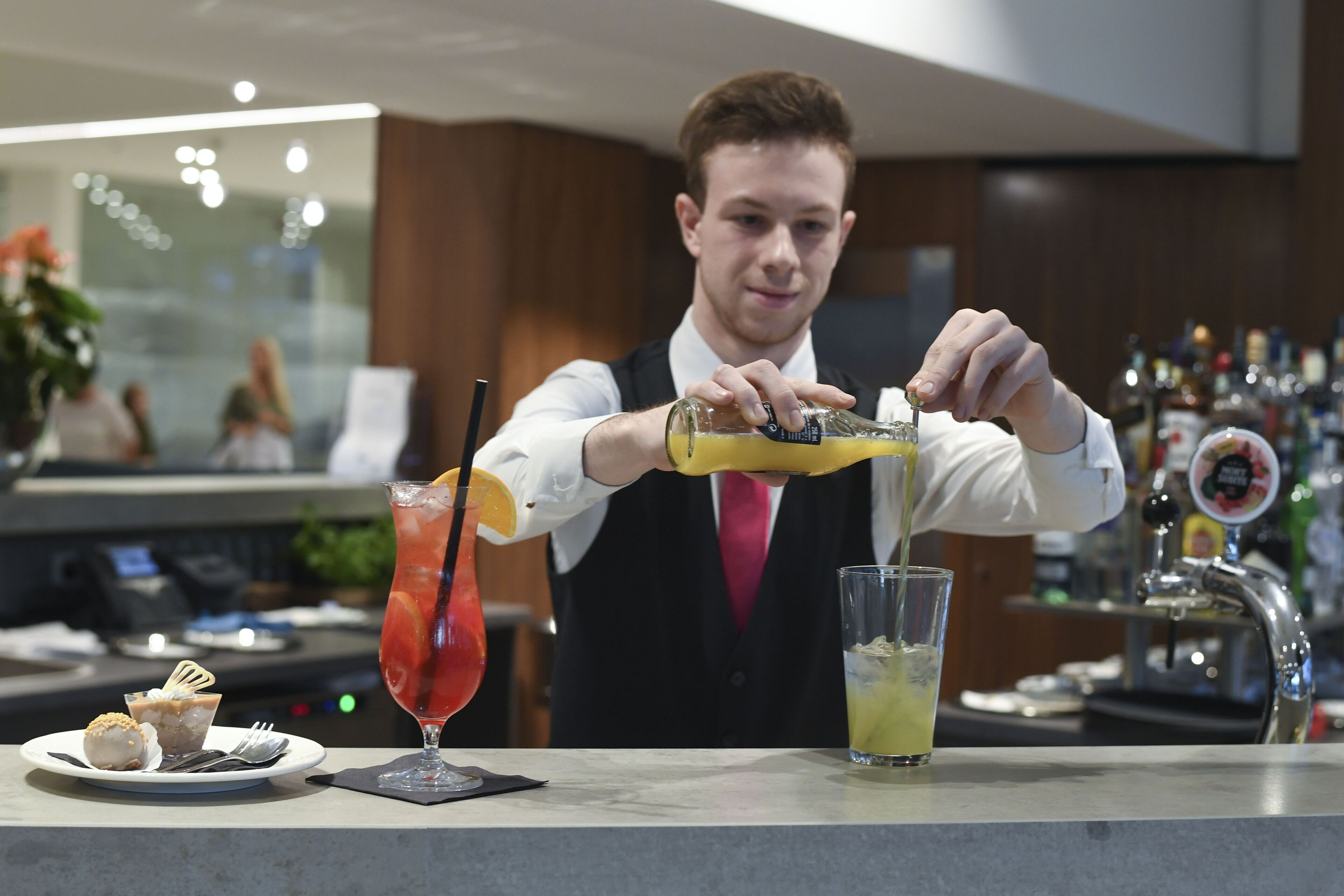 Un barman verse une boisson dans un verre.