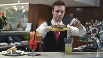 Un barman verse une boisson dans un verre.