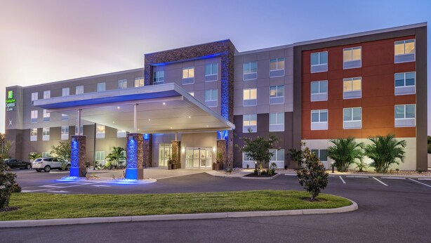 Un bâtiment de l’hôtel Holiday Inn Express doté d’une entrée couverte, d’une fontaine et d’un parking.