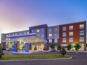 Edificio de Holiday Inn Express con un acceso cubierto, una fuente y un estacionamiento.