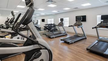 A gym with multiple treadmills, stationary bikes, and weight machines.