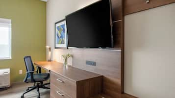 A modern office space with a wooden desk, a chair, a flat-screen TV mounted on the wall, and a framed abstract artwork.
