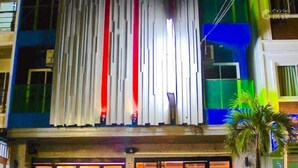 A building with a modern facade, featuring vertical slats and a mix of blue, green, and white colors. - Small Shells Hotel Phuket (Patong)