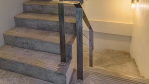 A staircase with a metal handrail and light fixtures on the walls. - Small Shells Hotel Phuket (Patong)