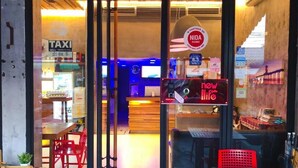 A modern interior with a reception desk, a sign for NIDA rooms, and a 'new life' sign. - Small Shells Hotel Phuket (Patong)