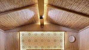 Un dormitorio con techo alto inclinado y pared decorada con paneles de madera.