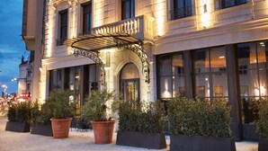 Un hotel de varios pisos con fachada clásica, amplias ventanas y una entrada bien iluminada.