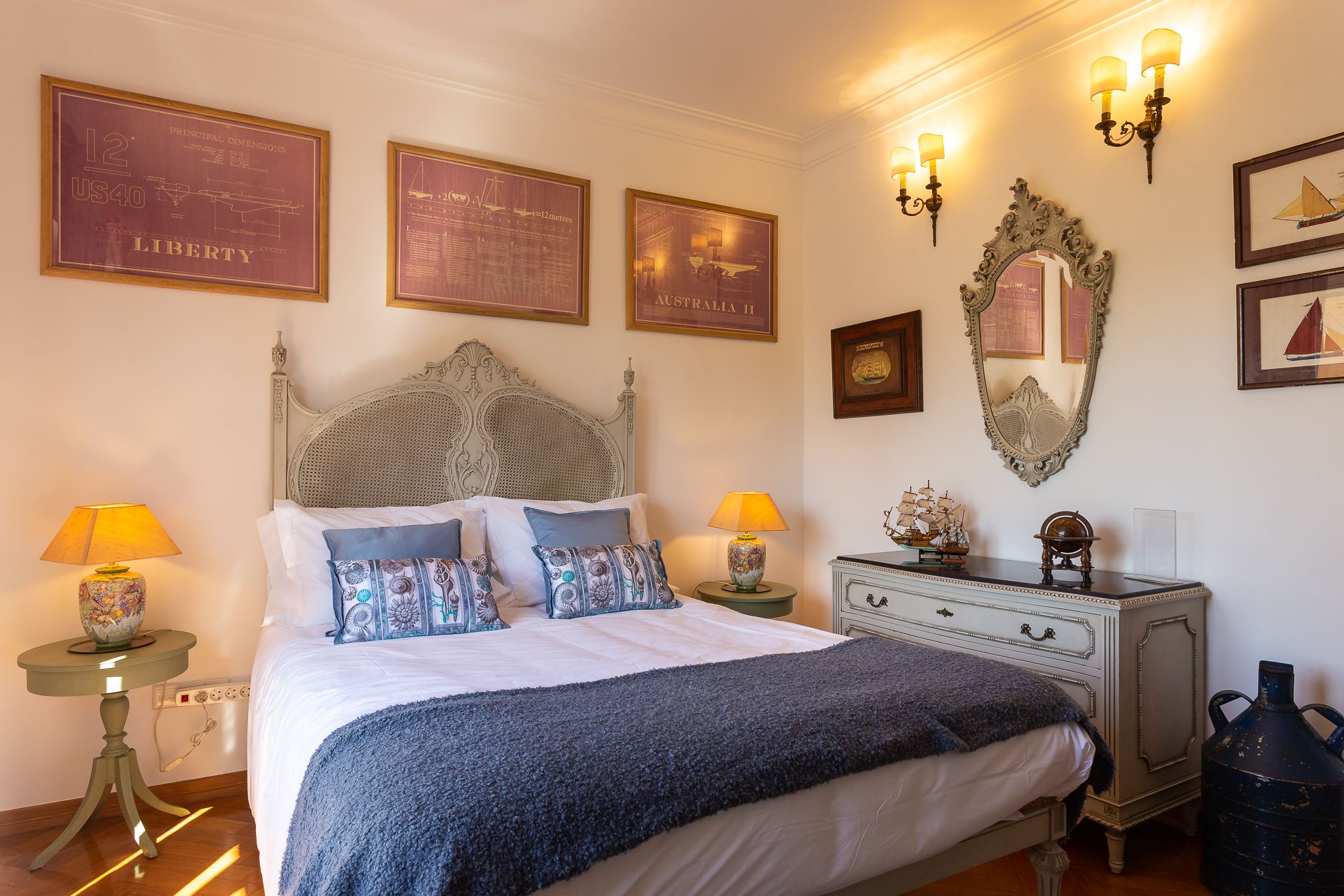 Un dormitorio con una cama grande, dos mesitas de noche con lámparas, un aparador y luces en la pared.