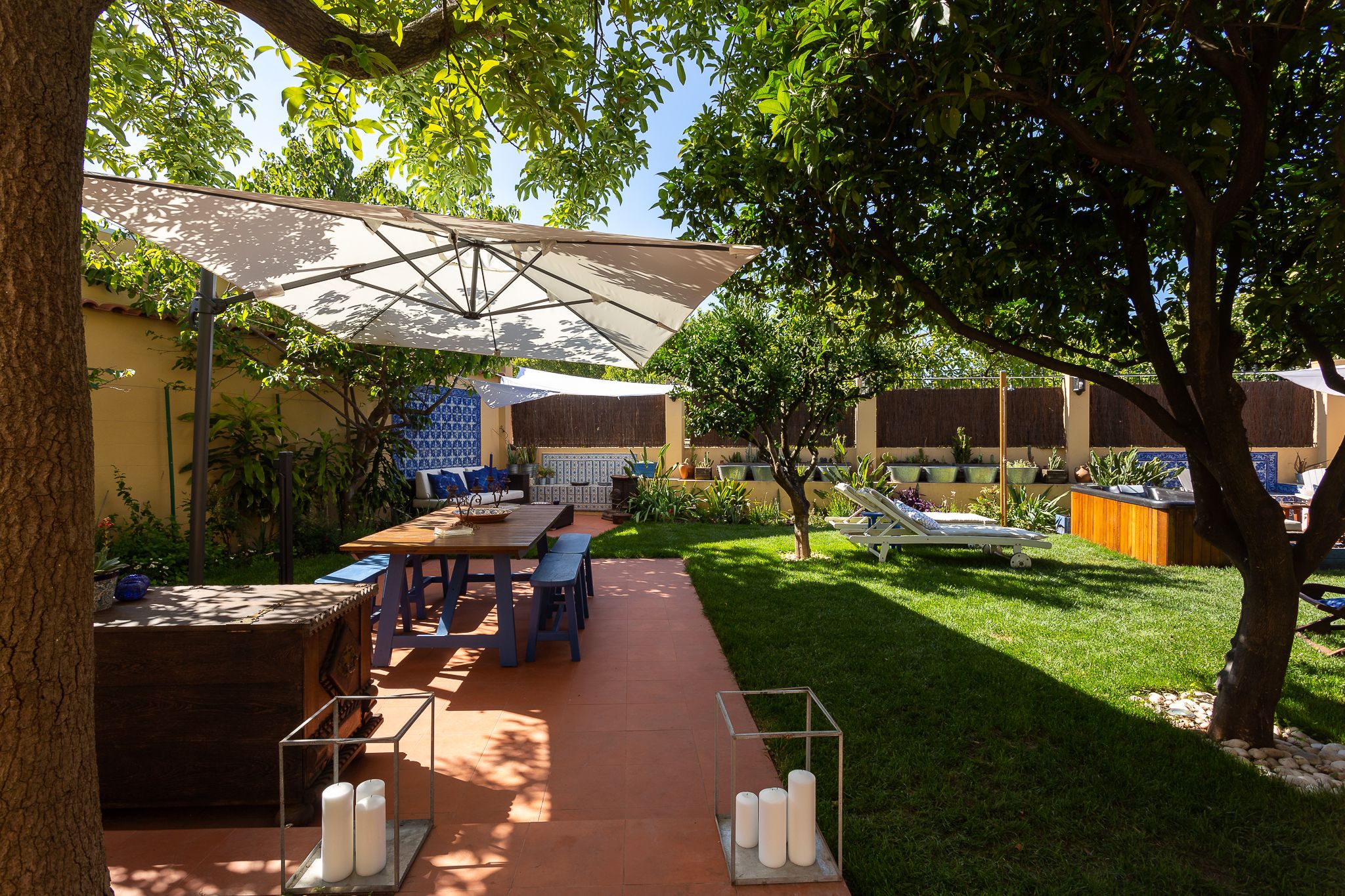 Un patio al aire libre con una mesa, sillas y una sombrilla grande.