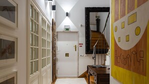 A hallway with a door, a staircase, and a wall with a geometric pattern. - Geronimo Guest House Belém (Lisbon)