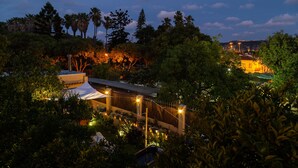 A hotel with a white tented structure, surrounded by lush greenery and palm trees. - Geronimo Guest House Belém (Lisbon)