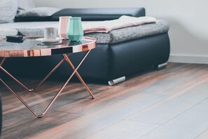 Una sala de estar moderna con una mesa redonda, un sofá y una alfombra.