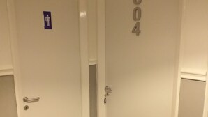 A hallway with two doors, one marked with a wheelchair accessibility sign and the other with a number 604. - Hostel alexander (Naples)