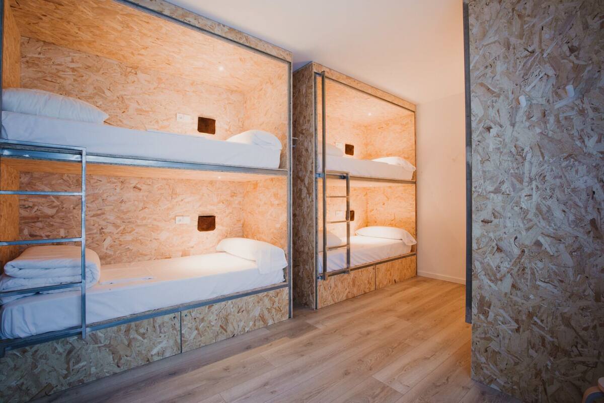 A room with bunk beds and a wooden wall.