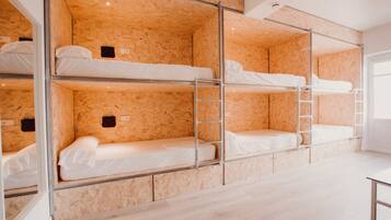 A bunk bed room with wooden walls and metal ladders.