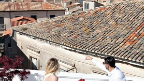 A rooftop terrace with a table set for two, overlooking a cityscape with terracotta roofs and a view of the sea. - Agriturismo Il Casanova (Baschi)